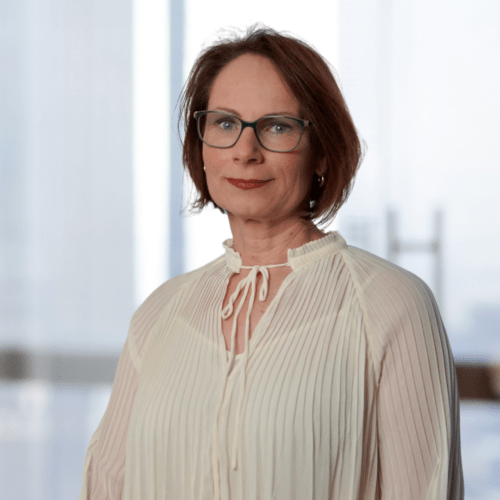 a woman wearing glasses and a white blouse