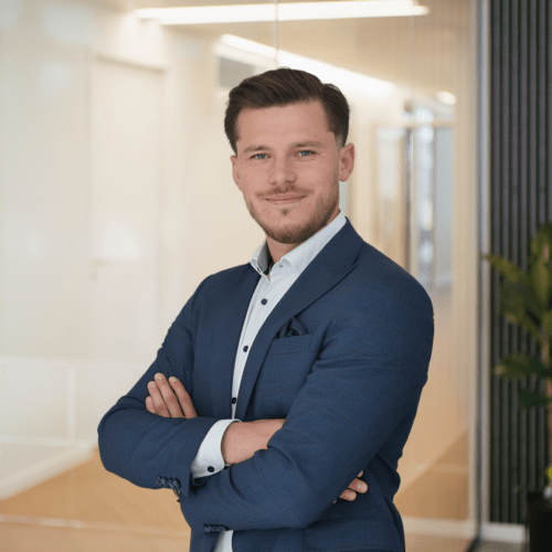 Arber Jakupi a man in a suit with his arms crossed