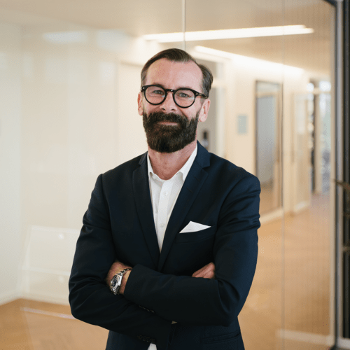 Marco Beyfuß a man in a suit with his arms crossed